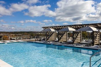 Rooftop pool with pergola cabanas and lounge seating